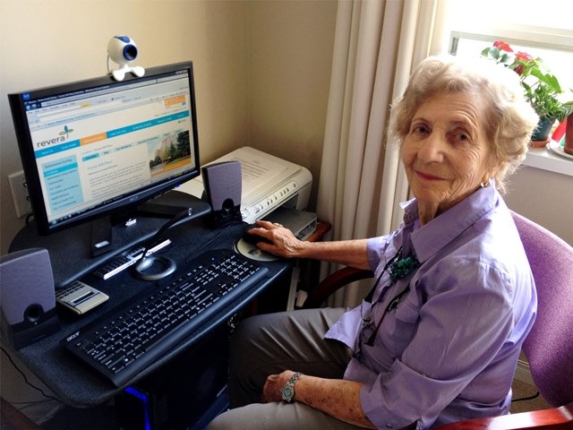 Aluna da terceira idade usando o computador em casa